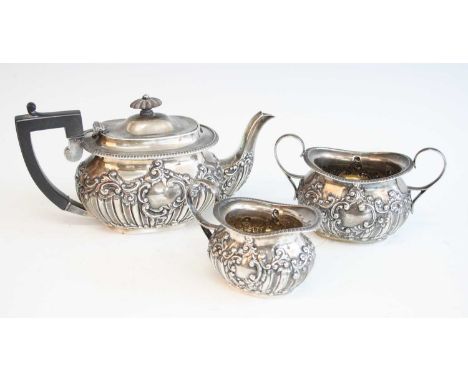 A late Victorian silver three-piece tea service, comprising teapot, twin handled sugar, and milk, each piece repousse decorat