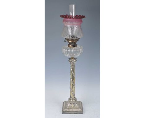 A Victorian silver plated oil lamp, having an acid etched cranberry tinted glass shade and cut glass font above a Corinthian 