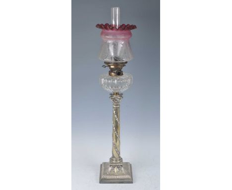 A Victorian silver plated oil lamp, having an acid etched cranberry tinted glass shade and cut glass font above a Corinthian 