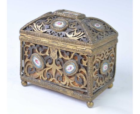 An early 19th century French pierced brass and enamel inset casket, of scrolling pierced form interspersed with Sevres style 