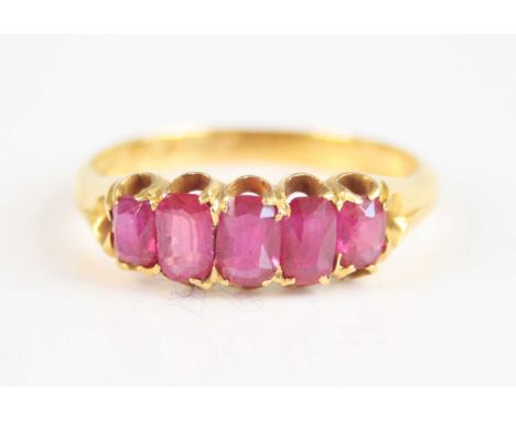 An 18ct yellow gold five stone ruby half hoop eternity ring, featuring five graduated oval faceted rubies in scalloped claw s