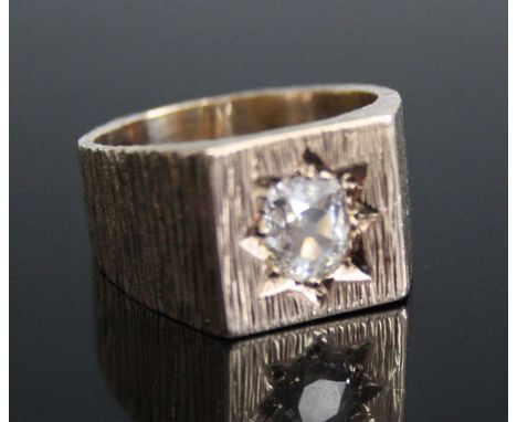 A gent's heavy 9ct gold diamond signet ring, the old cushion shaped diamond in a star setting to a yellow bark finish cast mo