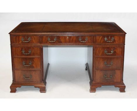 A mahogany twin pedestal desk in the Georgian style, mid-20th century, having a gilt tooled leather inset writing surface abo