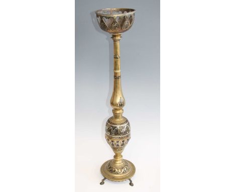 A large cast brass oil lamp stand, having a pierced circular bowl on tapered column to baluster base formed from a coconut ap