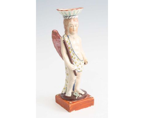 A circa 1800 Staffordshire pearlware figural candlestick, probably Neale &amp; Co, the flared sconce above the figure holding