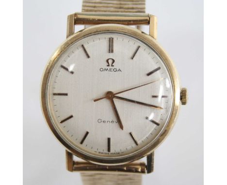 A yellow metal gent's Omega manual wind wristwatch, having a round cream baton dial and fitted to a 9ct yellow gold non-Omega