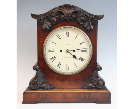 An early Victorian mahogany bracket clock, the case with applied leaf and flower carvings, the restored circular white enamel