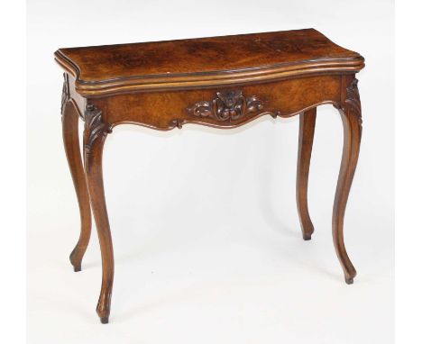 A Victorian figured walnut card table in the French taste, the fold-over four quarter veneered top on pull-out rear action an
