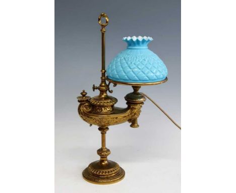 A 19th century German Wild &amp; Wessel brass oil lamp, having a blue quilted glass shade (a/f), the body with relief mask an