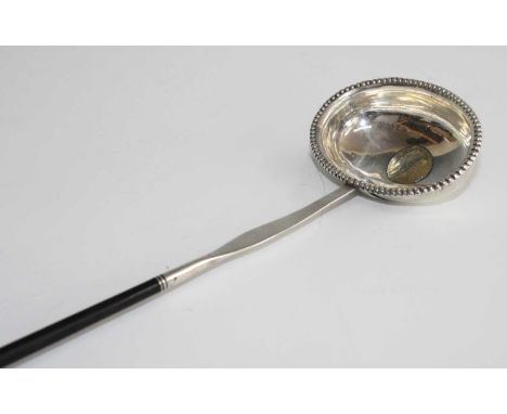 A George II/III white metal toddy ladle, the unmarked oval bowl having a beaded rim and inset with a 1758 gilt coin and attac