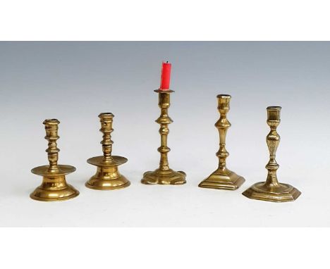 A pair of 18th century Heemskerk brass candlesticks, each having multi-knopped mid-drip stems and standing upon a circular fo