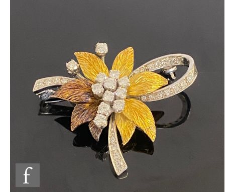 An 18ct hallmarked diamond set floral spray brooch with central daisy cluster to a two coloured gold leaf design and diamond 