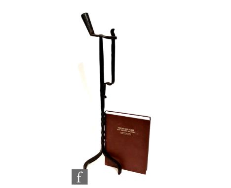 A 17th century floorstanding rush light holder, twist stem on tripod base, height 74cm, and a signed copy of the book The Rus