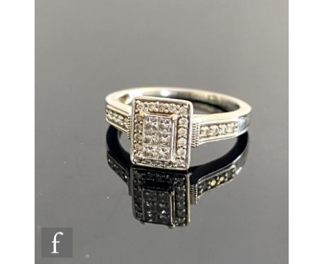 A modern 9ct hallmarked white gold diamond cluster ring, rectangular stepped head falling to diamond set shoulders, weight 4.