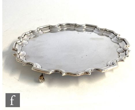 A hallmarked silver card waiter of plain form with scalloped border, diameter 20cm, weight 12.5oz, Edinburgh 1994,&nbsp;Laing