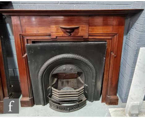 An Edwardian mahogany fire surround, the shelf projecting over a half round bracket and moulded internal frieze, with cast ir