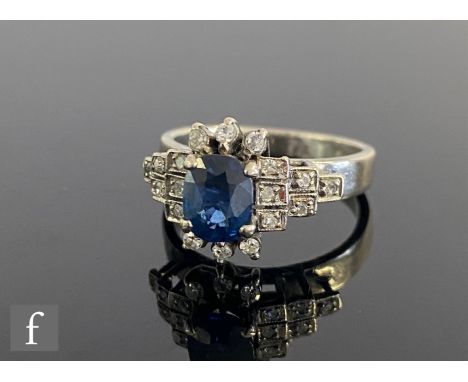 An 18ct white gold sapphire and diamond cluster ring, central oval sapphire, length 6.8mm, within a diamond set border and di