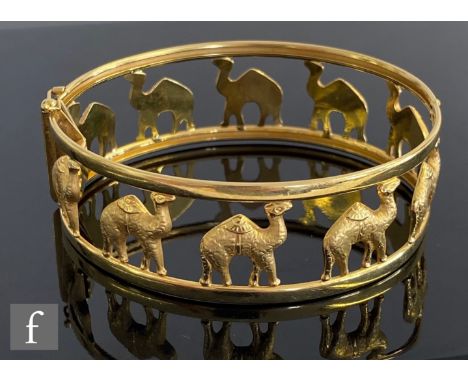 A later 20th Century 18ct pierced hinged bangle decorated with ten standing camels, weight 23.5g, internal diameter 6.5cm at 