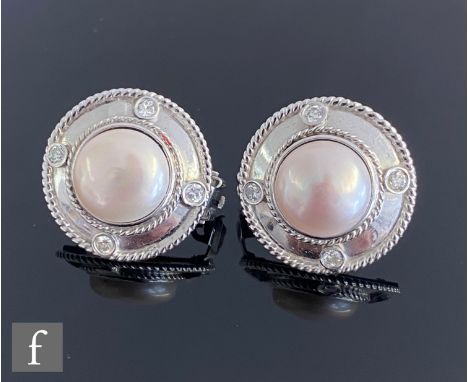 A pair of 9ct hallmarked white gold mabe pearl and diamond stud earrings, central pearl within a rope twist border detailed w