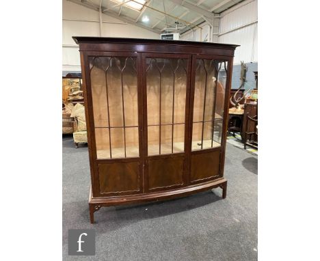 An Edwardian mahogany bowfront display cabinet enclosed by three bar glazed doors in the Chippendale style, 178cmx 46cm x 162