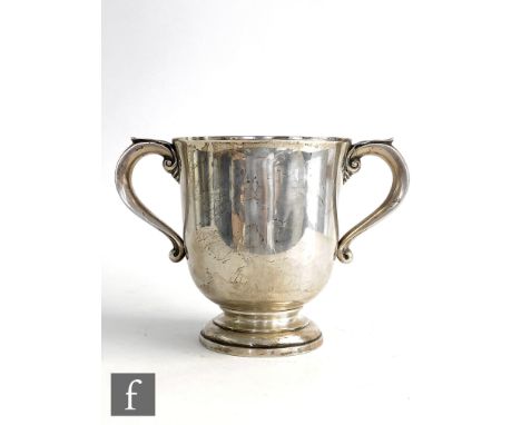 An Art Nouveau hallmarked silver two handled cup of plain form raised to a stepped foot, height 14cm, weight 16.5oz, crest ha