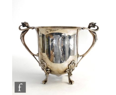 An Art Nouveau hallmarked silver twin handled ice bucket of plain form raised on four scroll feet and terminating in scrollin