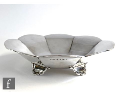 A hallmarked silver bowl of plain cushioned octagonal form raised on four scroll feet, diameter 21cm, weight 9oz, London 1935