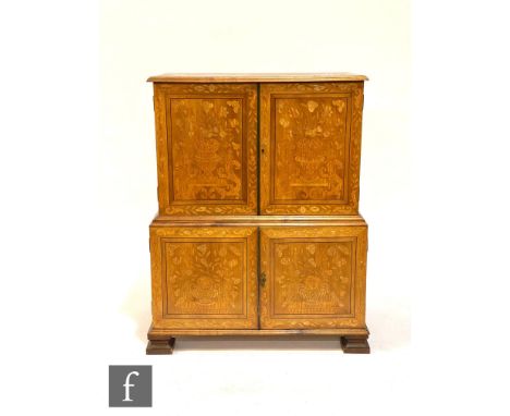 A 20th century Dutch style marquetry inlaid cabinet enclosed by a double pair of doors inlaid with vases of flowers, birds an