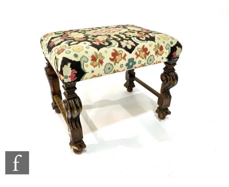 A 19th century continental walnut dressing stool on shaped ends united by later end rails, upholstered in floral tapestry, wi