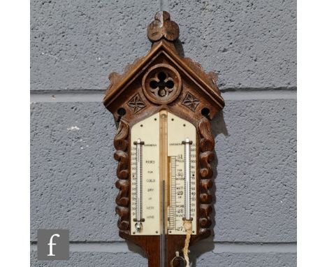 A late 19th Century Gothic Revival oak stick barometer, the architectural pediment above twin dry and wet registers, unnamed,