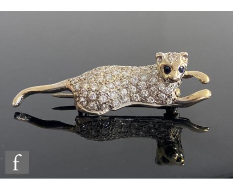 An 18ct white gold diamond set brooch modelled as a panther with sapphire set eyes, length 4.5cm, weight 7.8g, unmarked. 