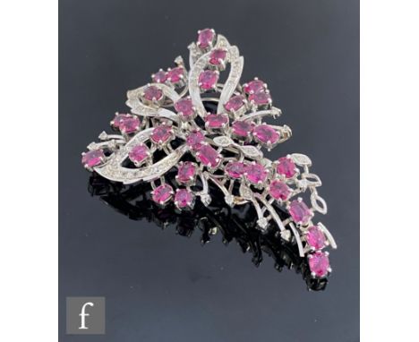 A silver and white gold plated ruby and diamond set tapering brooch, claw set rubies and pave set diamonds to a stylised leaf