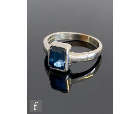 A modern 9ct hallmarked white gold single stone iolte ring, collar set, emerald cut collar set stone to plain shoulders, weig