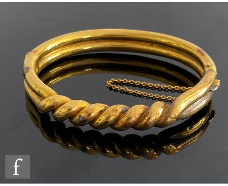 An early 20th Century 18ct hinged bangle with central rope twist detail, weight 19g, S/D. 