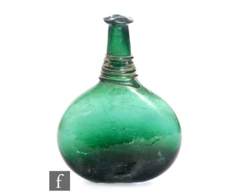 An early 19th Century Persian green glass saddle flask of compressed ovoid form with tall tapered neck and applied green trai