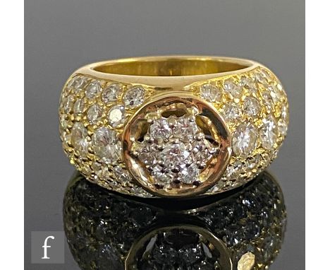 An 18ct hallmarked diamond ring, central floating daisy cluster within a gold border and flanked with pave set diamond should