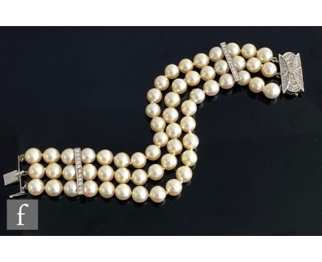 A triple row cultured pearl bracelet with two diamond set spacer bars and terminating in a 14ct white gold pave diamond set c