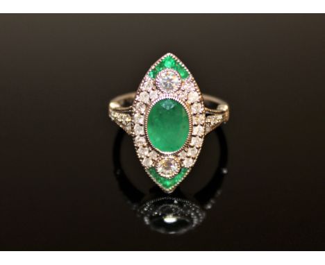 An 18ct white gold emerald and diamond ring, the central oval-cut emerald of medium-green colour weighing 1.23 carat, surroun