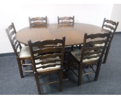 A circular oak pedestal dining table with leaf together with a set of six tapestry seated ladder back chairs 