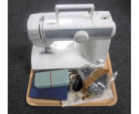 A Toyota electric sewing machine with foot pedal and accessories together with a boxed hip flask