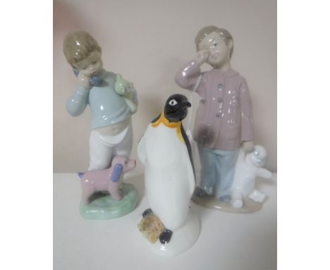 Two Nao figures of boys with teddy bears together with a Poole figure of a penguin