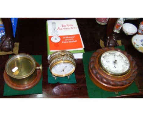 A desk barometer, together with two others and books on the same