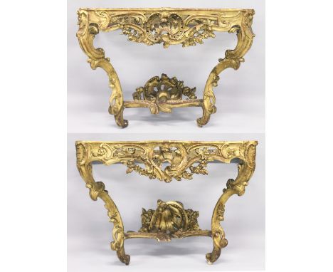 A VERY GOOD NEAR PAIR OF 18TH CENTURY CARVED AND GILDED CONSOLE TABLES with serpentine marble tops. the base carved with scro