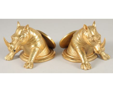 A PAIR OF GILT BRONZE RHINO DESK WEIGHTS. 5ins long.
