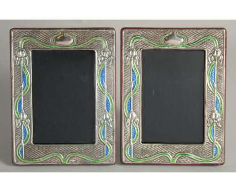 A PAIR OF SILVER AND ENAMEL PHOTOGRAPH FRAMES. 7.5ins X 5.5ins.
