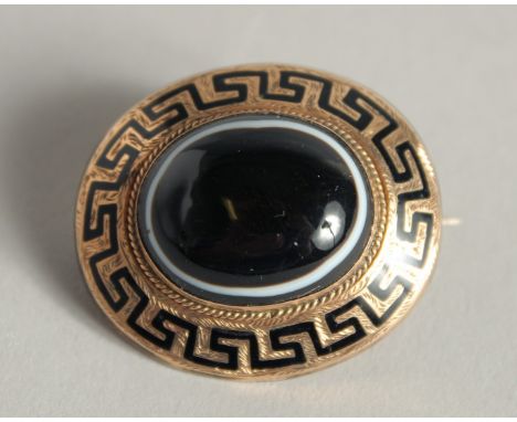 A VICTORIAN GOLD AND BLUE ENAMEL CIRCULAR BROOCH with key pattern decoration and with a single agate stone and inset for hair