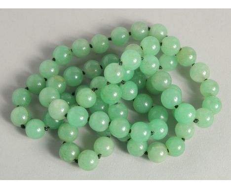 A STRING OF JADE BEADS 34ins long.