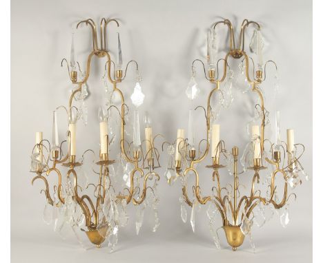 A PAIR OF ORNATE BRASS AND CUT GLASS WALL LIGHTS, of two tier form with four light fittings to each, with numerous cut glass 