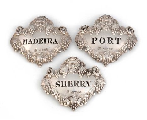 A set of three Victorian silver wine labels, by Robert Garrad, London 1851, shaped oval form with vine and grape border surmo