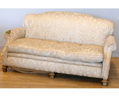 An early 20th century mahogany framed three seat sofa, with shaped back, sweep back and scroll arms, sprung upholstery, raise